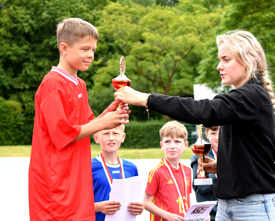 Hier erhält der Drittplatzierte der Altersklasse 2015, Levin Schmidt von der Wieseschule, den Pokal von LAZ-Trainerin Maya Klute überreicht. Foto: Bottin
